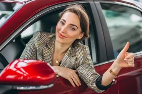 Donna al volante con pollice in su